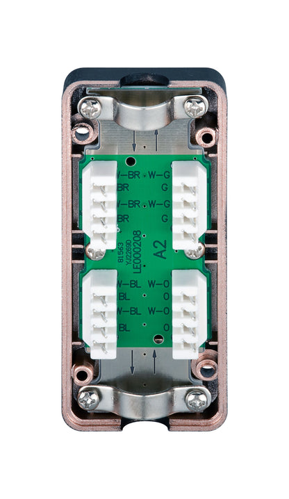 Terminalblok med grøn PCB, hvide stik, mærkede terminaler og metalbeslag ved siden af Skærmkabel UTP Cat. 6.