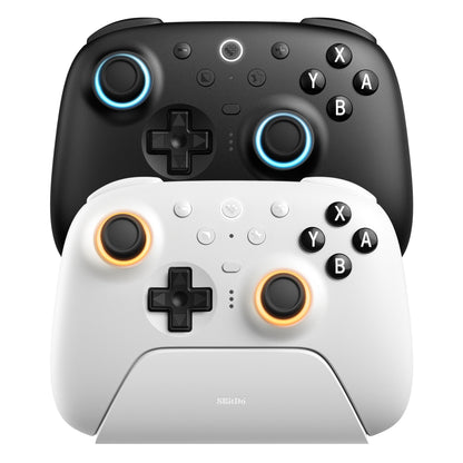8Bitdo Ultimate 2 Bluetooth controller sort og hvid med farvede LED-ringe, den hvide på stander med 8Bitdo logo.