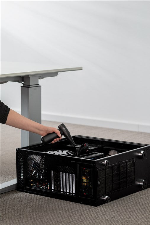 Goobay Håndblæser Superior 180W sort blæser støv fra åben PC-tower på gulv ved siden af højdejusterbart skrivebord.