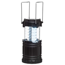 LED campinglanterne i sort cylinderform med to metalhåndtag, klar midte udsender hvidt lys ved udfoldning.
