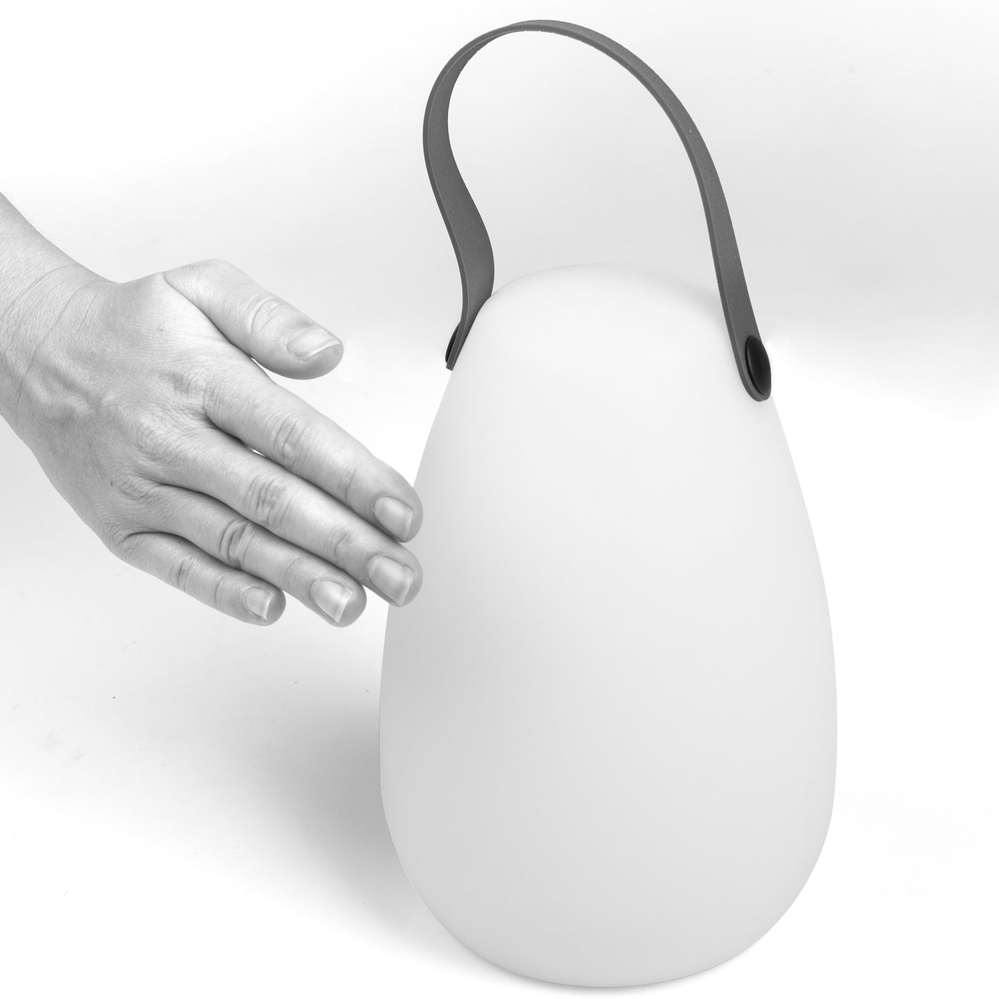 Genopladelig udendørs lanterne med buet hank, æggeformet design og mat overflade, hånd rækker mod lampen.