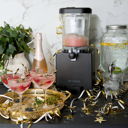 Champion Slush Ice Maskine 1L sort med fire hindbær-cocktails, glasbeholder med citron-vand og mousserende vin.