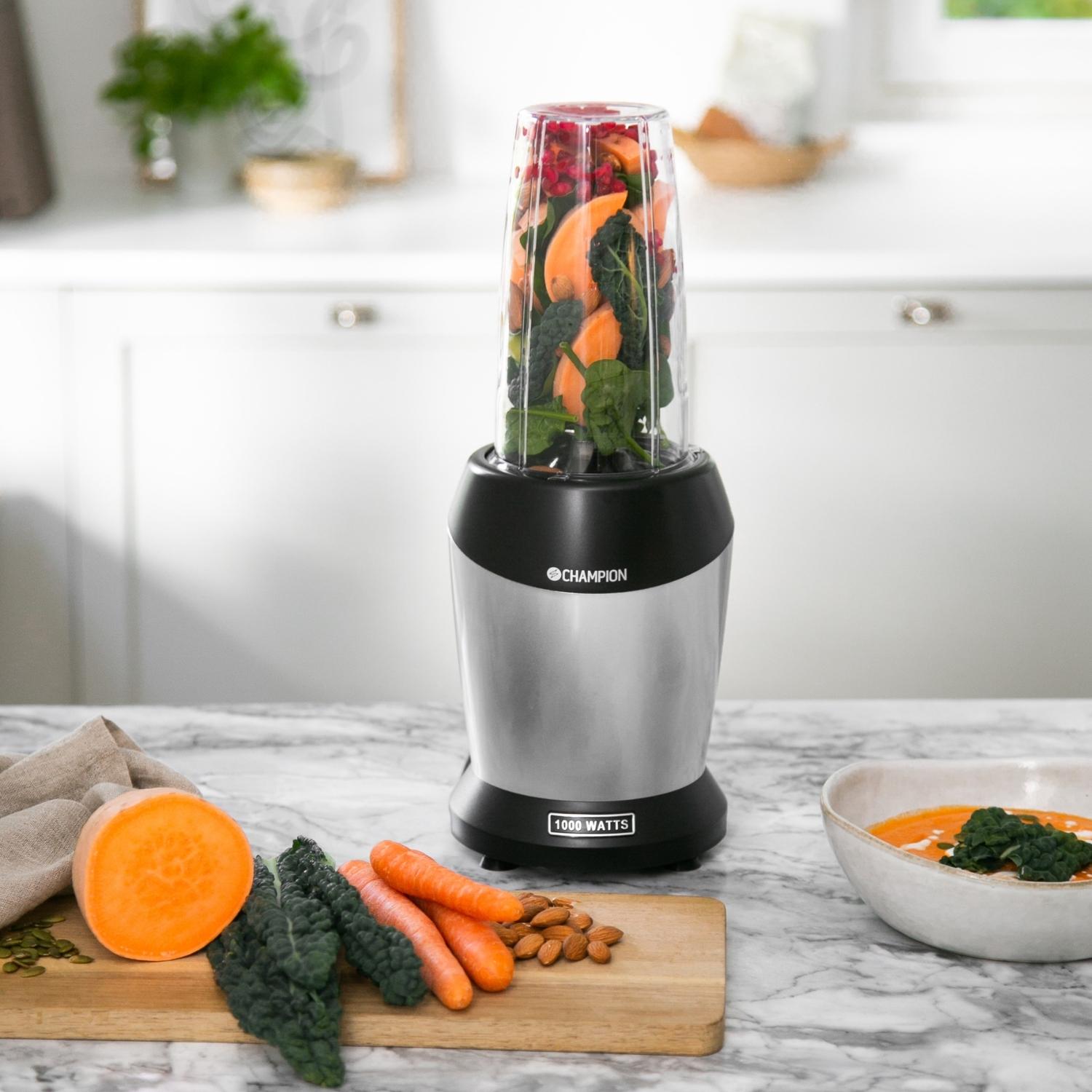 Champion Smoothie Blender 1000W sølv/sort på køkkenbord, fyldt med grøntsager, BPA-fri Tritan-holder.