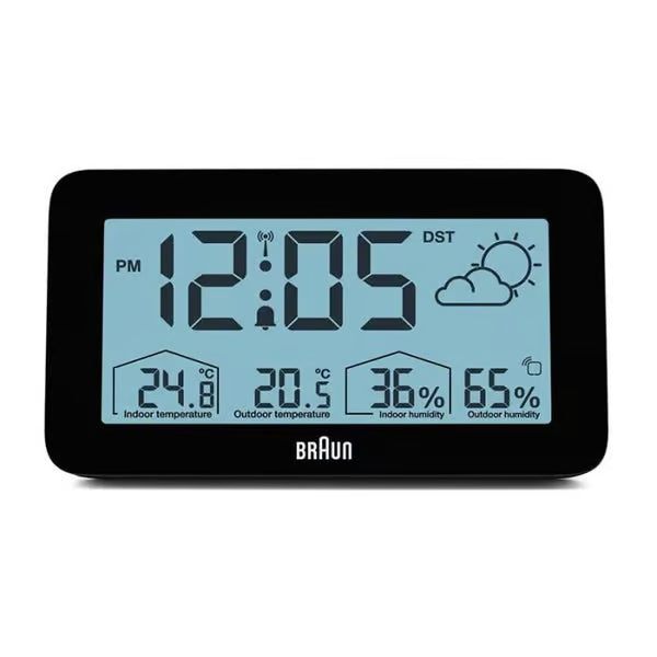 BRAUN digital vejrstation, sort, rektangulært LCD-display med blå baggrund, viser klokkeslæt, vejr, temperatur 24,8 °C/20,5 °C og luftfugtighed 36 /65 .