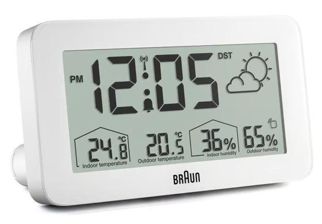 Radiostyret digitalt vækkeur i hvidt med display til tid, vejrsymbol, indendørs/udendørs temperatur og luftfugtighed, sommertid.