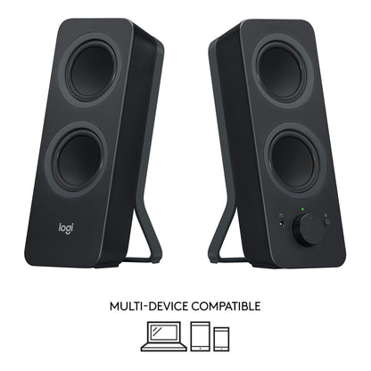 Logitech Z207 sorte computerhøjttalere med lydstyrkeknap, jackstik og Bluetooth-knap med ikoner, der angiver enhedskompatibilitet.