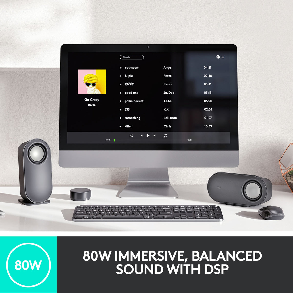 Logitech Z407 højttalersystem med subwoofer, trådløs lydstyrkekontrol og to højttalere på skrivebordet ved computeren.