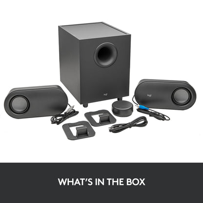 Logitech Z407 højttalersystem med subwoofer, to ovale satellithøjttalere med stativer og cirkulær trådløs lydstyrkekontrol.