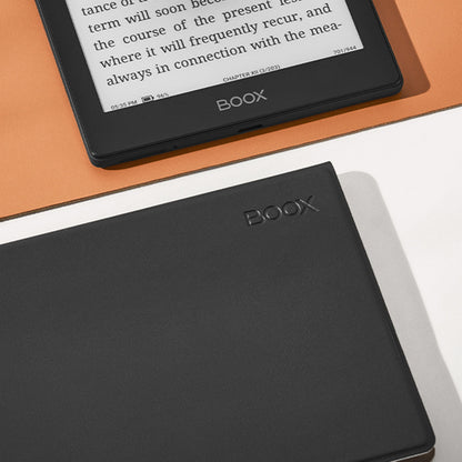 Boox Onyx Gå 6 e-boglæser med magnetisk etui, visning af bogtekst, ved siden af lukket sort Boox Onyx enhed på orange flade.