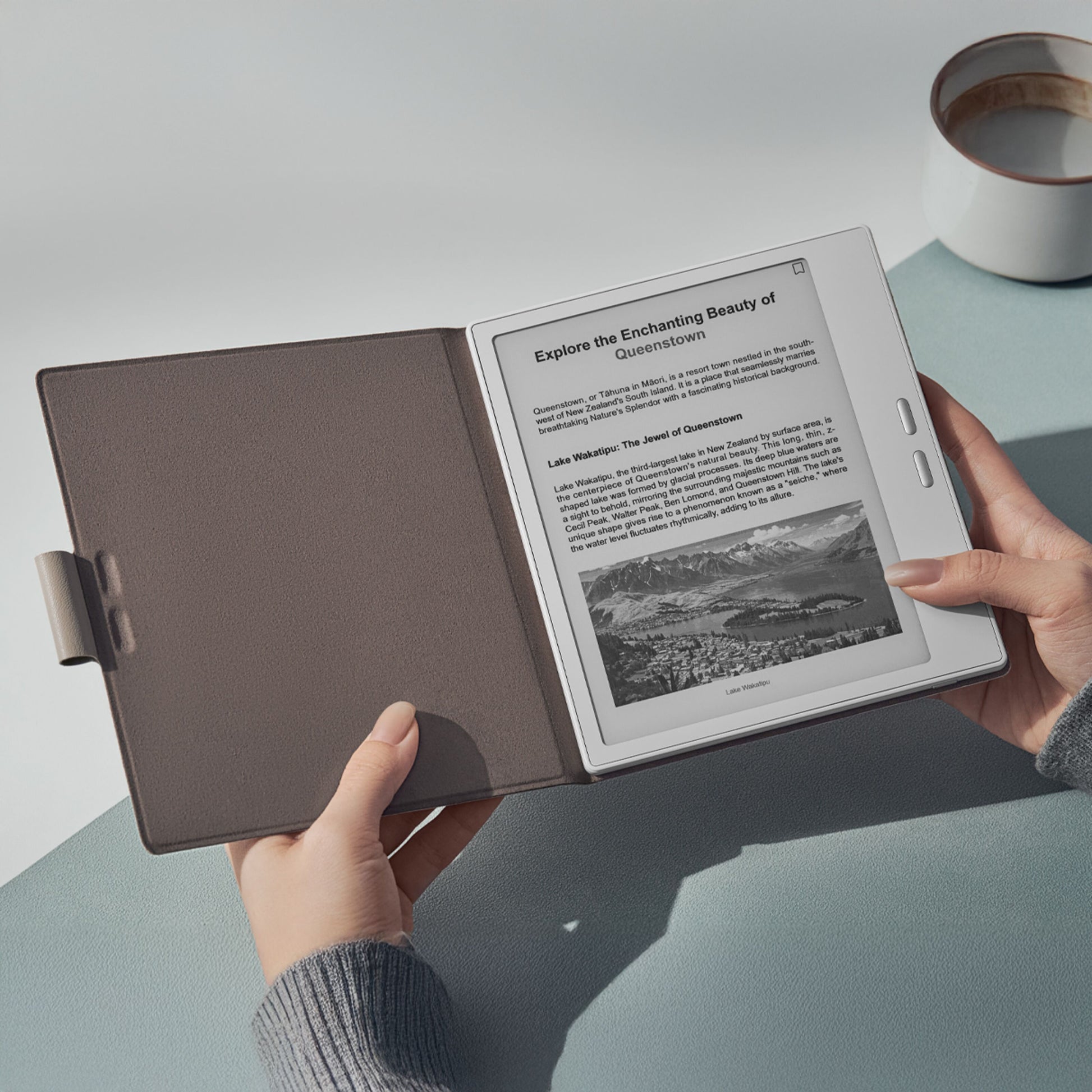 Boox Go 7 e-bogslæser i beige magnetisk etui til Go 7-serien, viser artikel med by og bjerge.