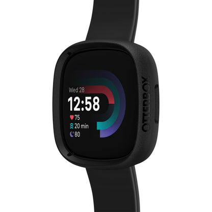 Fitbit Versa 4 smartwatch sort med sort silikonearmbånd, Otterbox Se Bumper, viser dato, tid, puls og skridt.