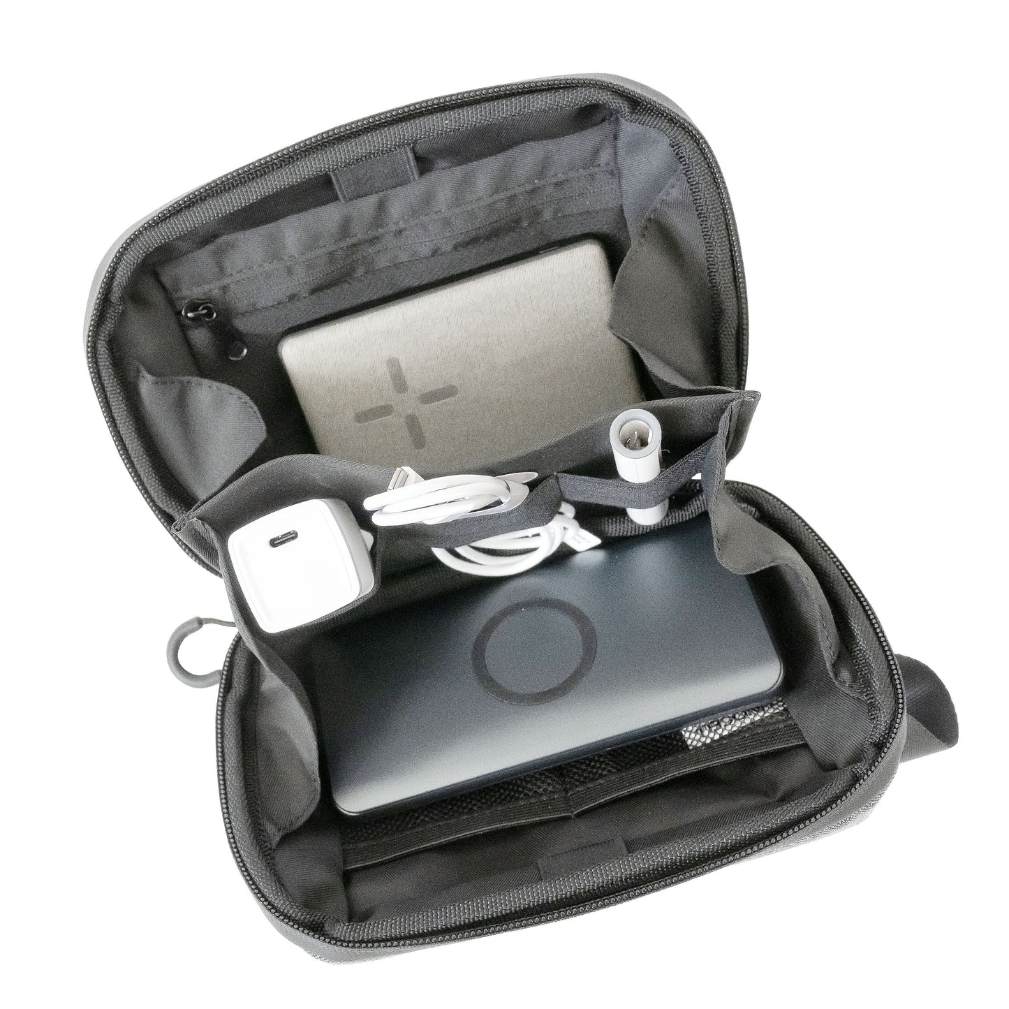 Linocell teknologitaske i sort vandafvisende nylon med separate rum til powerbank, kabler, adaptere og rund enhed.