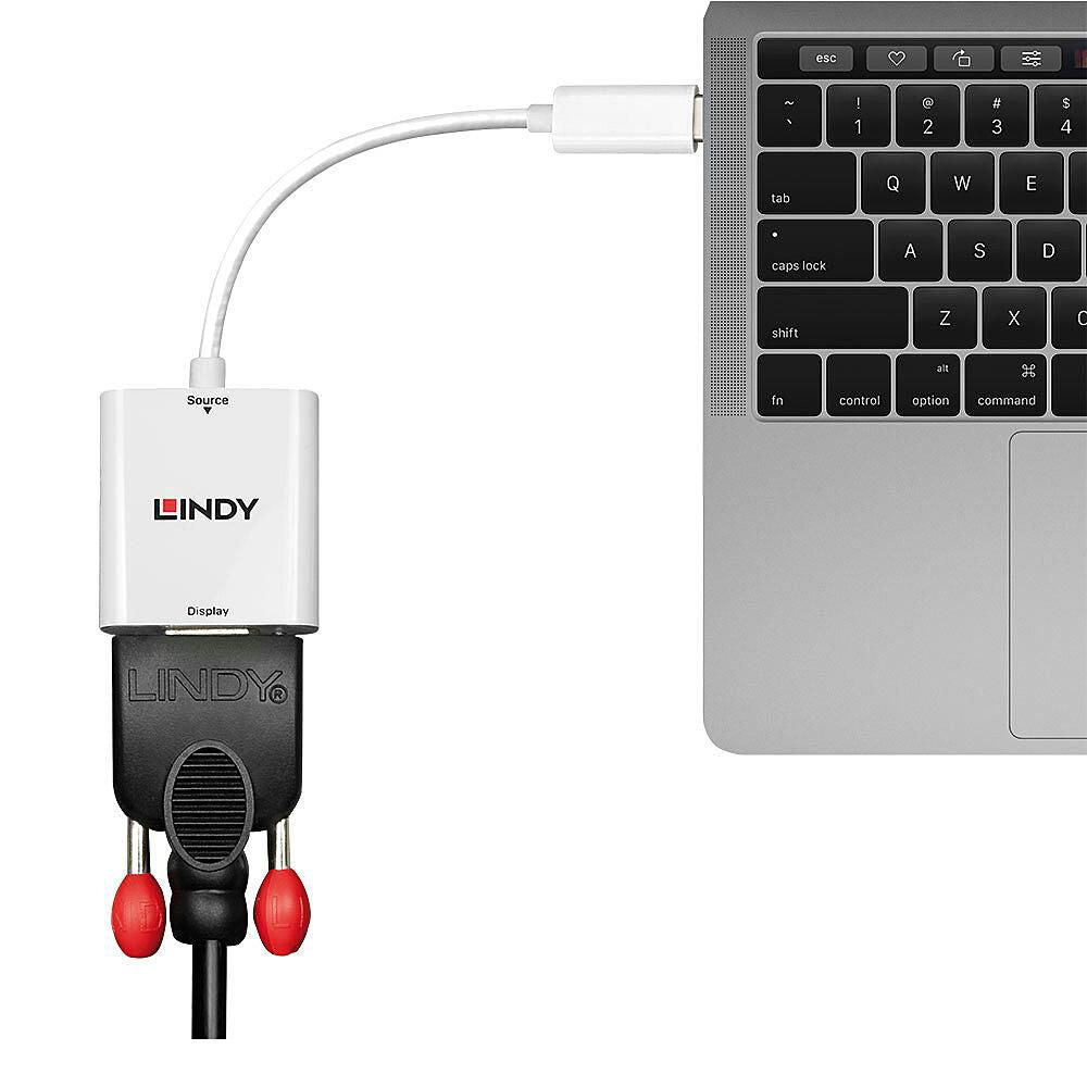 USB-C til VGA Converter med tilsluttede røde/hvide RCA-kabler, delvis synlig laptops tastatur og trackpad.