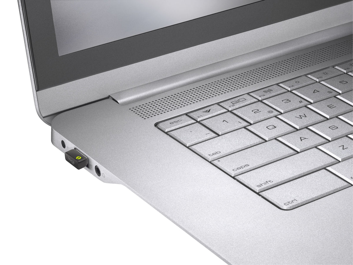 Billede af en Logitech Logi Bolt USB-modtager, der er sat i en port på en sølvfarvet bærbar computer.
