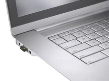 Billede af en Logitech Logi Bolt USB-modtager, der er sat i en port på en sølvfarvet bærbar computer.
