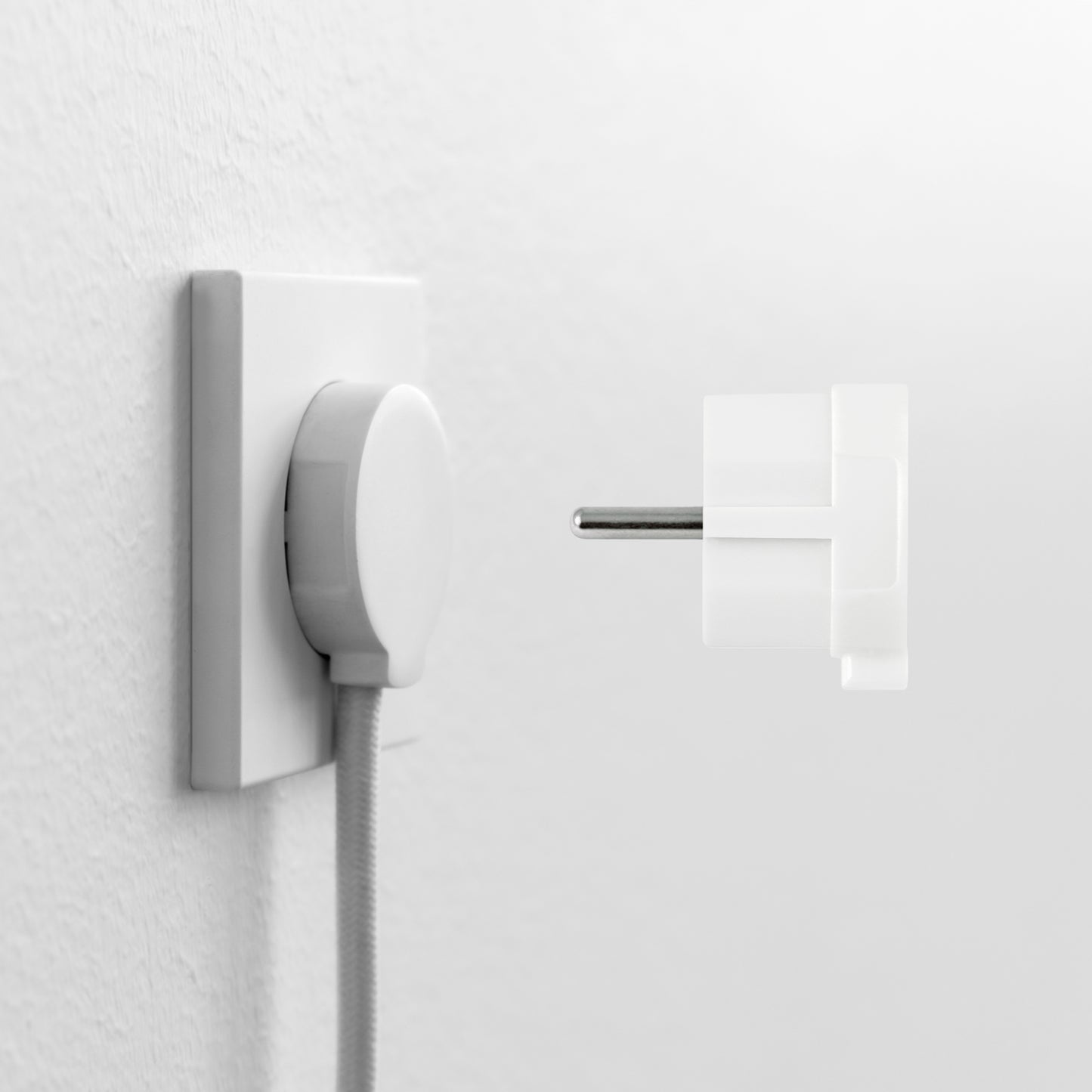 NORM stikprop Schuko, hvid, delvist transparent, tæt ved stikkontakt med tilsluttet kabel.