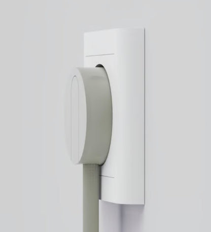 NORM K stikprop grå uden jord isat i hvid stikkontakt, fladt design med ledning nedad, set tæt på.