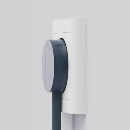 Blå oval NORM K stikprop med jord tilsluttet hvid stikkontakt, tilhørende kabel hænger ned.