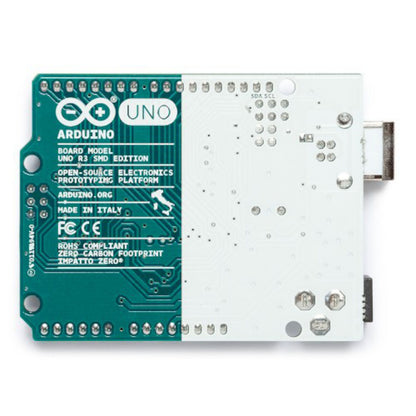 Bagsiden af Arduino Uno Rev. 3 SMD udviklingskort med ATmega328P, mærkater, komponenter og USB-stik til højre.