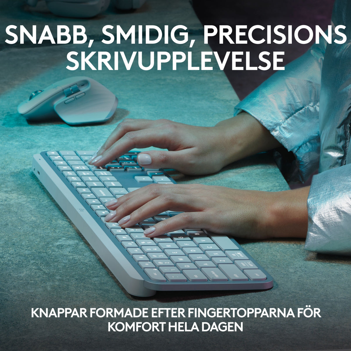 Hænderne skriver på et lysegråt, trådløst Logitech MX Keys S-tastatur med lavprofiltaster ved siden af en trådløs mus.