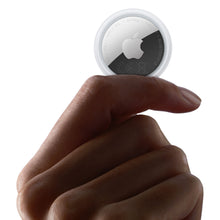 Apple AirTag 2. gen 1-pakning, sølv, holdes mellem tommel- og pegefinger med synligt Apple-logo.