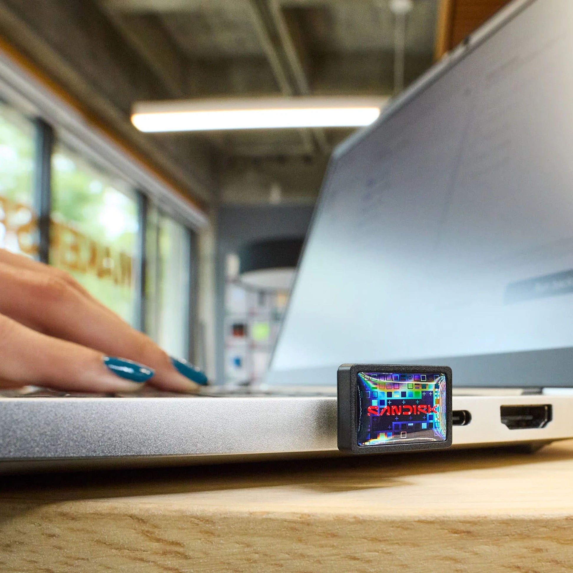 Sandisk Extreme Fit USB-C-hukommelse 128GB med holografisk label tilsluttet sølvlaptop.