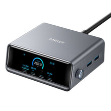 Anker Prime 250W GaN oplader grå med digitalt display, flere USB-C/USB-A-porte, kontrolknap og sort kabel bagpå.