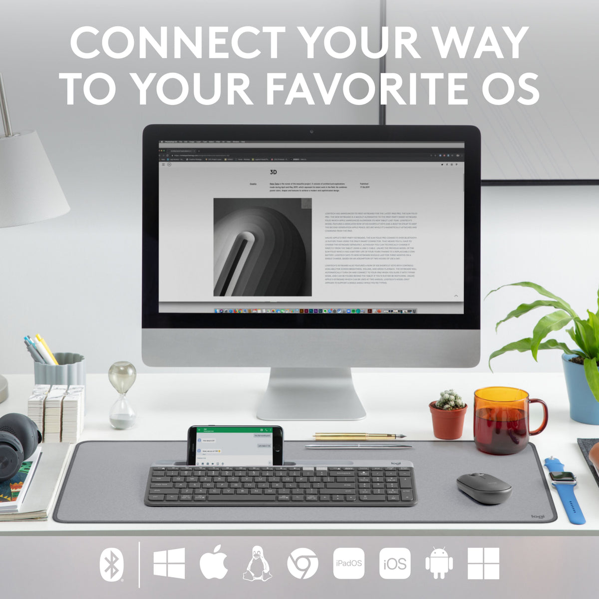 Logitech K580 trådløst tastatur med telefonholder, mus og skærm på skrivebordet med ikoner til operativsystemet.