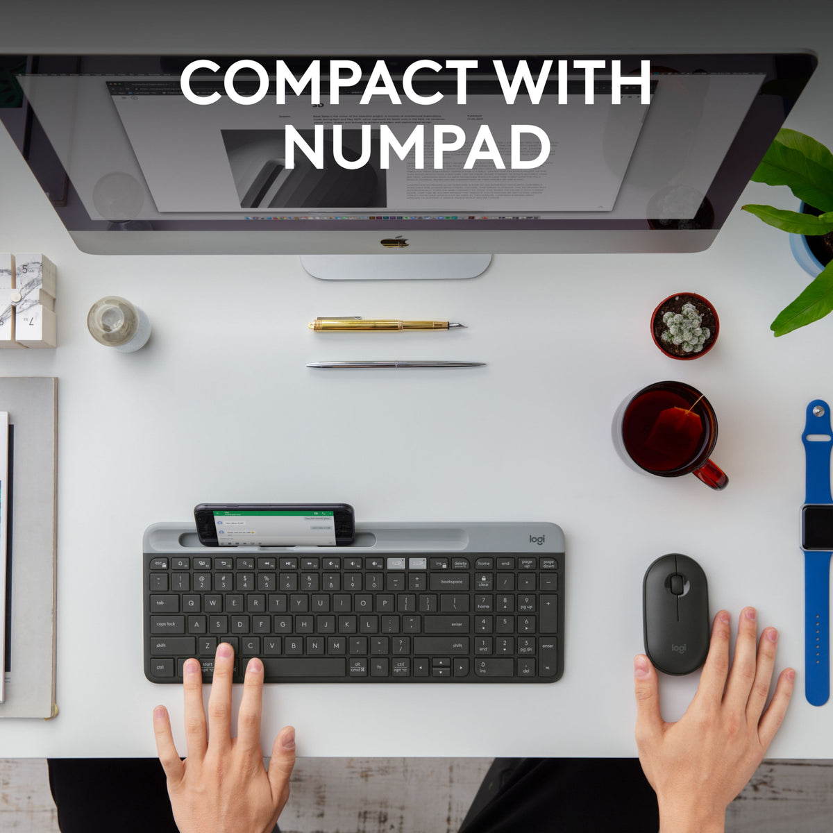 Gråt Logitech K580 Slim trådløst tastatur med numerisk tastatur og smartphone-holder på skrivebordet sammen med mus og skærm.