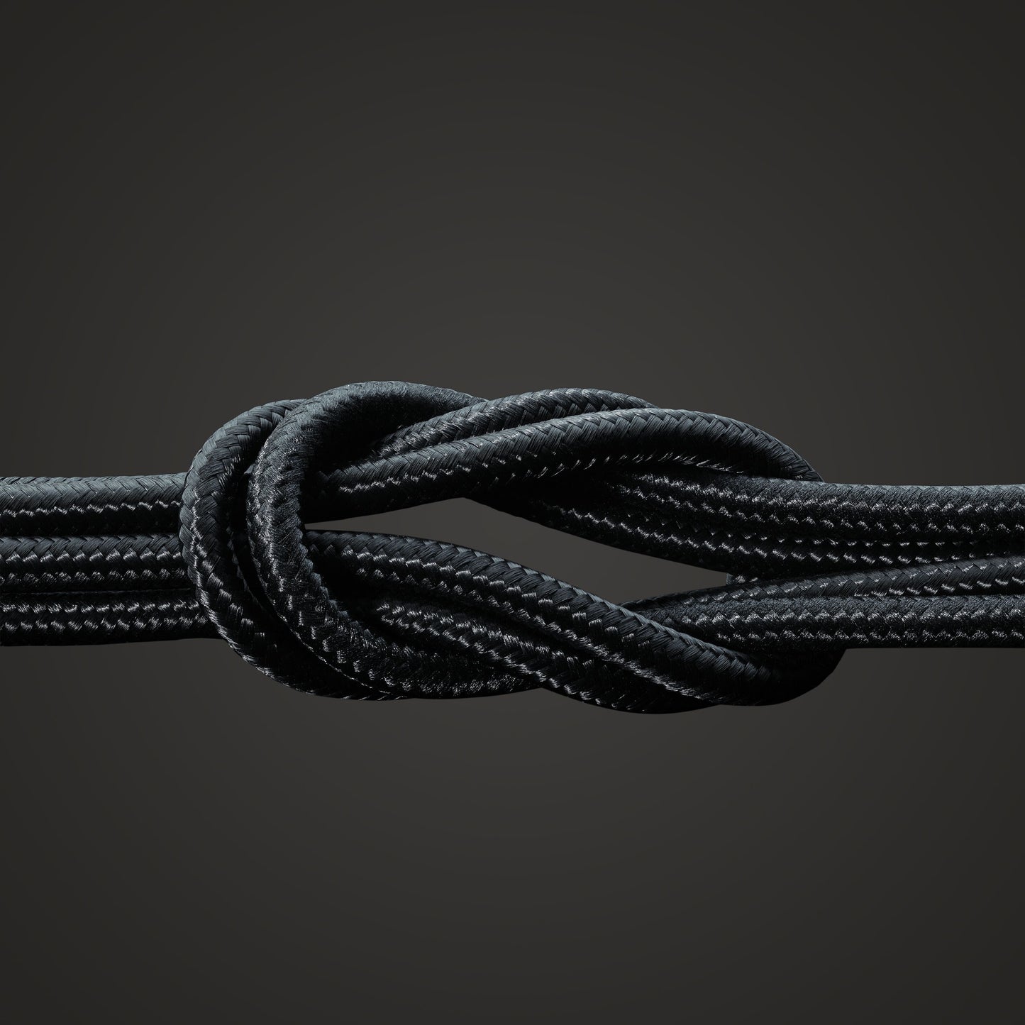 Linocell Premium Kevlar USB-C til Lightning-kabel MFi sort 1m tæt knude synlig tekstur mod mørk baggrund.