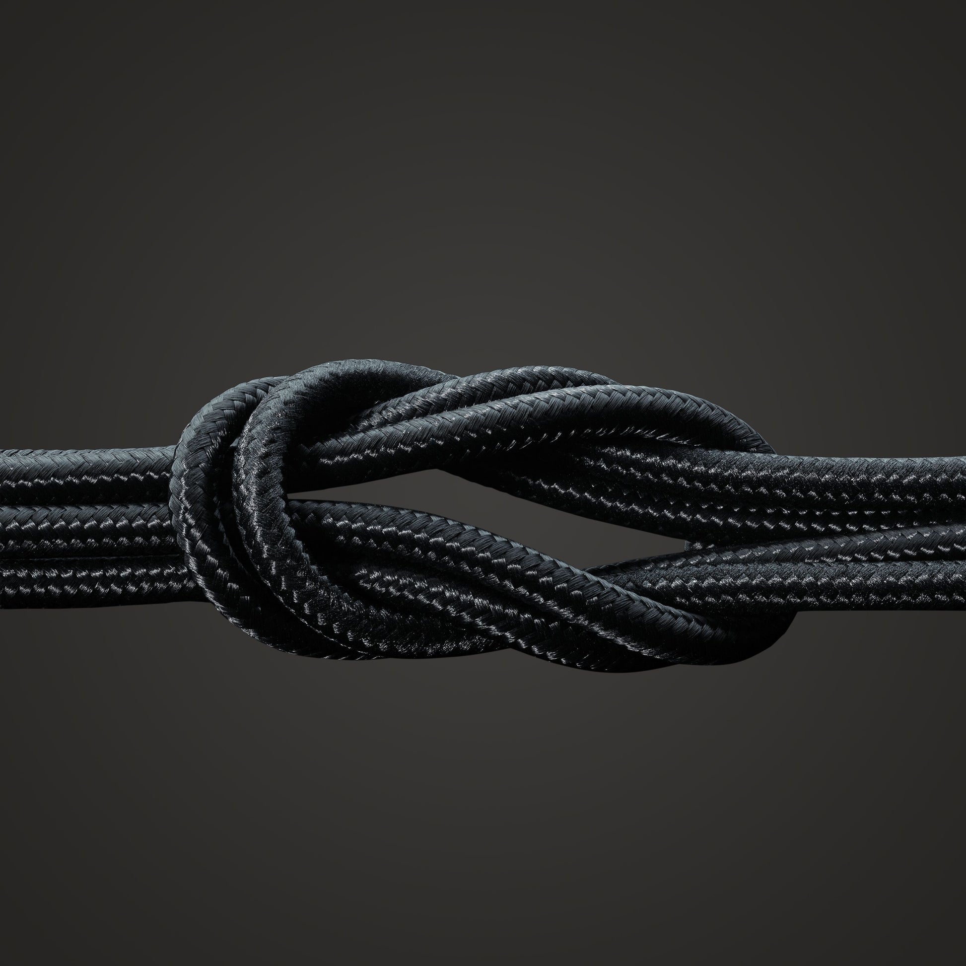 Linocell Premium Kevlar USB-C til Lightning kabel 2 m sort, kevlar og flettet nylon, vist i knude mod mørk baggrund.