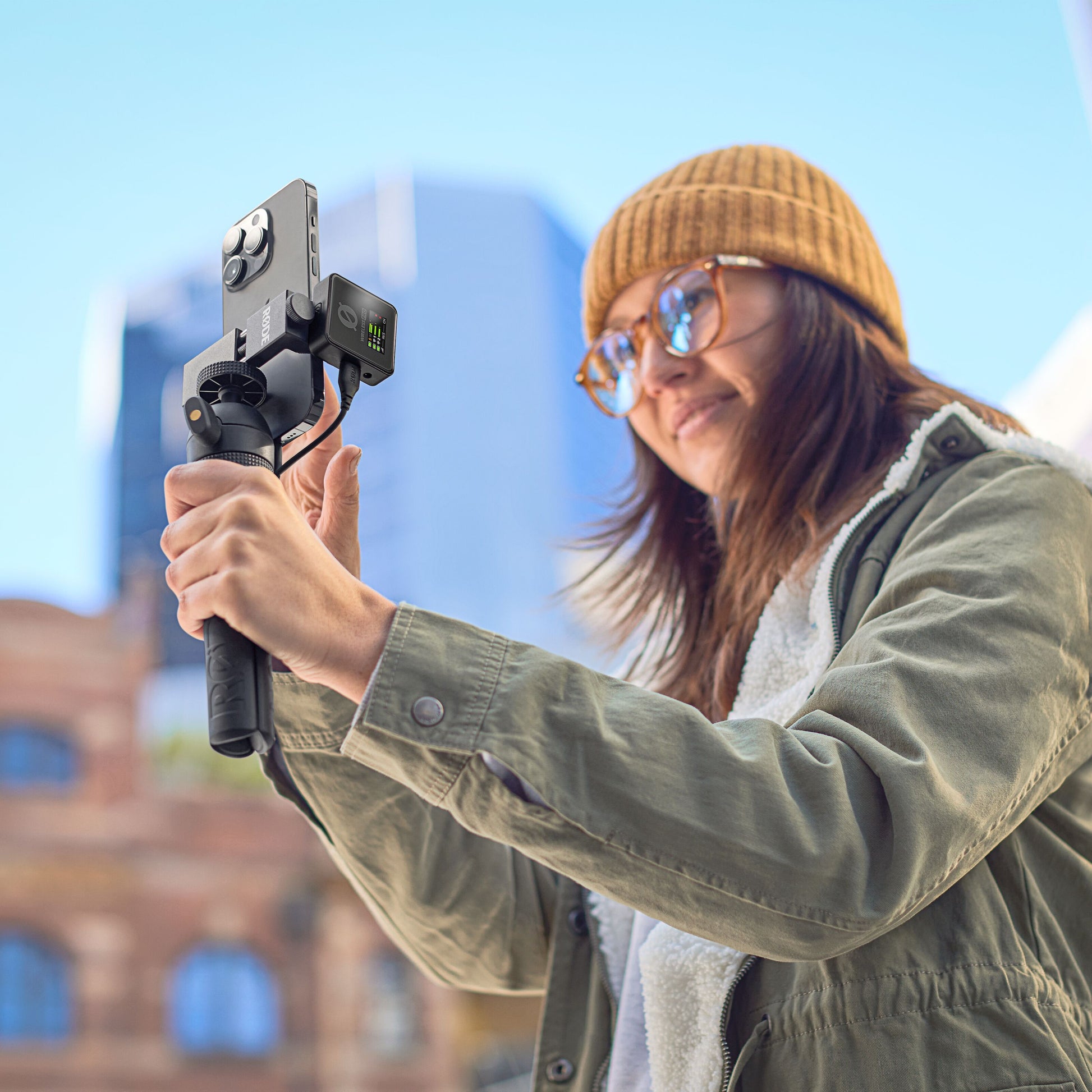 Røde Trådløst PRO trådløst mikrofonsystem på smartphone og håndholdt stabilisator i brug udendørs.
