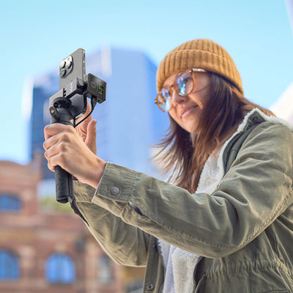 Røde Trådløst PRO trådløst mikrofonsystem på smartphone og håndholdt stabilisator i brug udendørs.