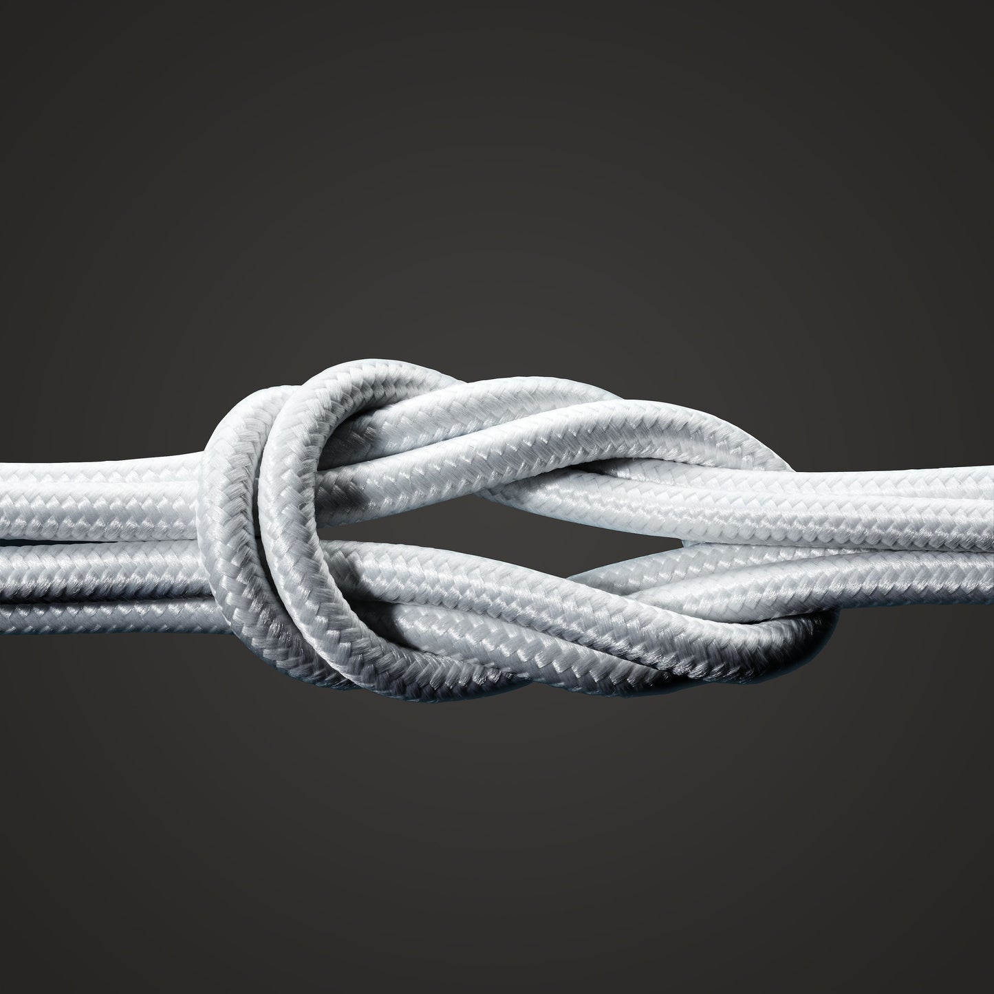 Linocell Premium Kevlar USB-C til Lightning kabel 0,5 m hvid MFi i knude close-up mod mørkegrå baggrund.