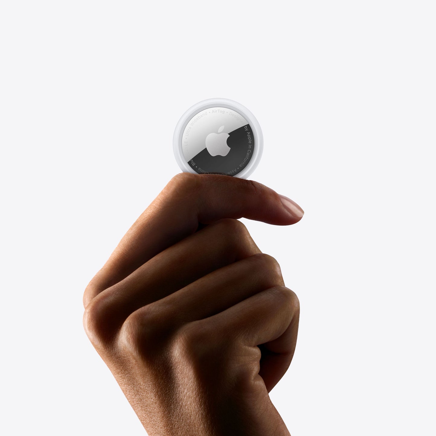 Apple AirTag 4-pak, lille rund enhed med hvid top, mørk cirkel med Apple-logo og tekst langs kanten.