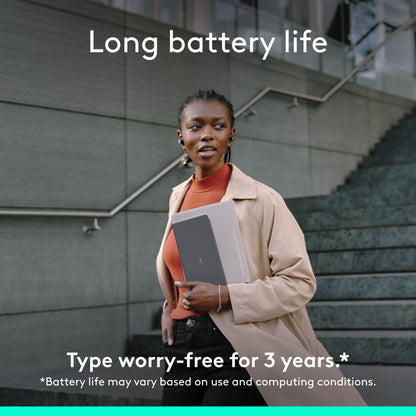 Sorter Logitech Keys-To-Go 2 bærbart Bluetooth-tastatur og tablet på en udendørs trappe med tekst om batterilevetid.