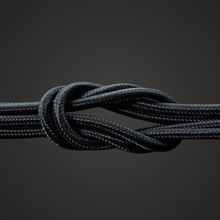 Linocell Kevlar USB-A til Lightning-kabel, MFi-certificeret, sort, 1 m, robust sort kabel i tæt knude på mørk baggrund.