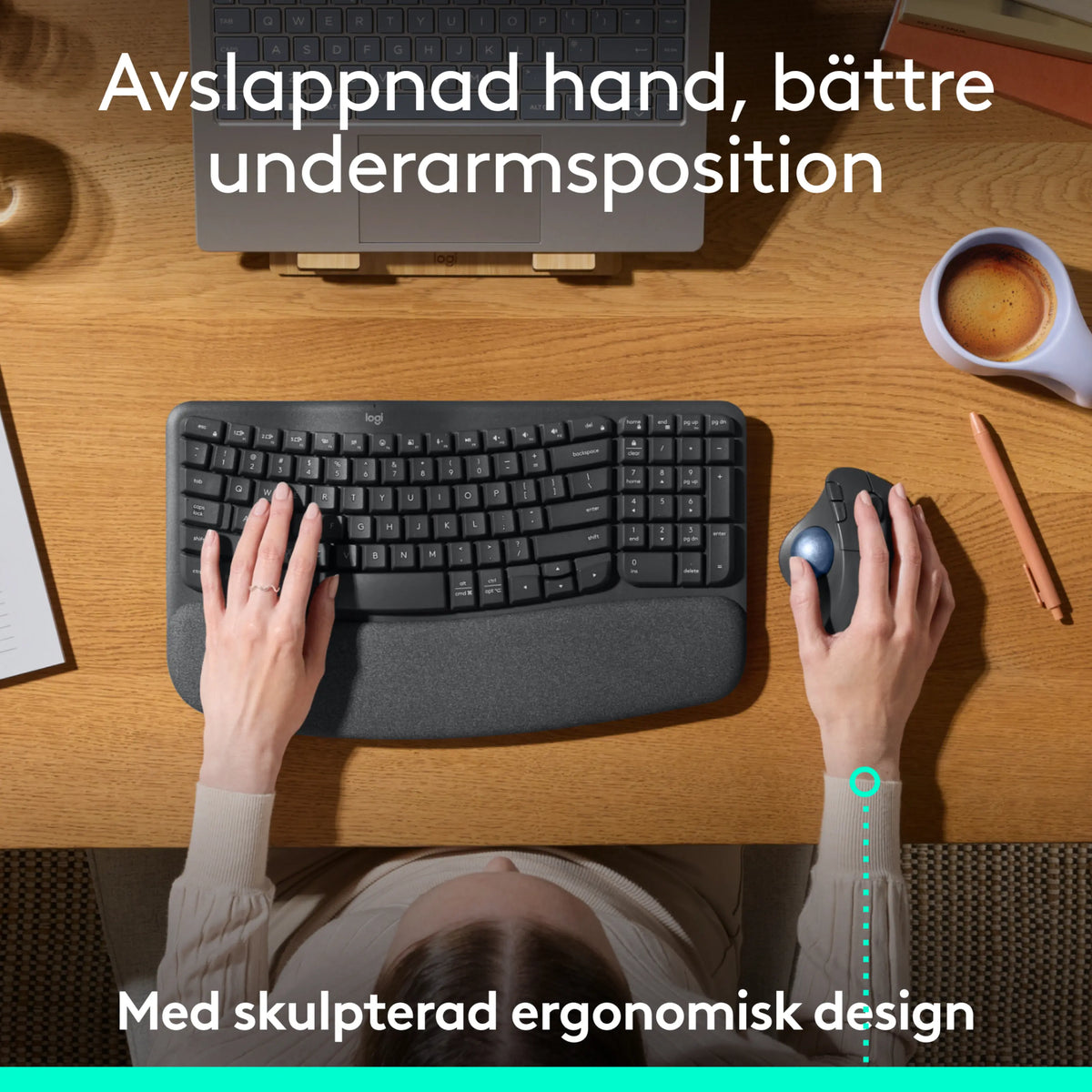Ergonomisk tastatur og mørkegrå Logitech Ergo M575S trådløs trackball-mus på et træbord.