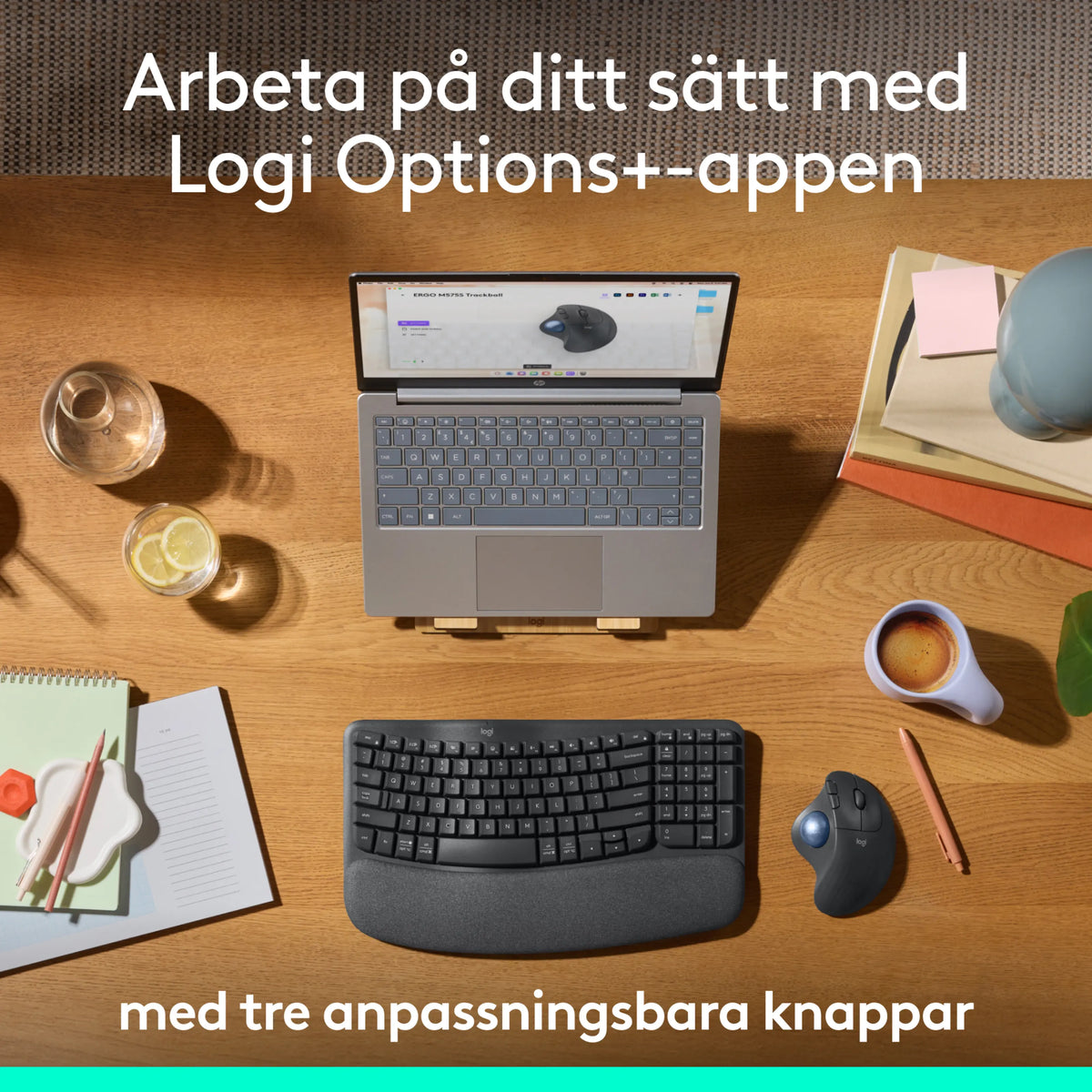 Logitech Ergo M575S trådløs trackball-mus i grafit, tastatur og bærbar computer på et træbord.