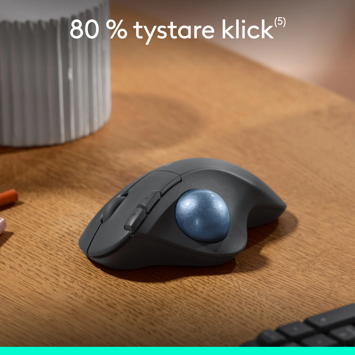 Logitech Ergo M575S trådløs trackball-mus i mørkegrå med blå kugle placeret på et træbord.