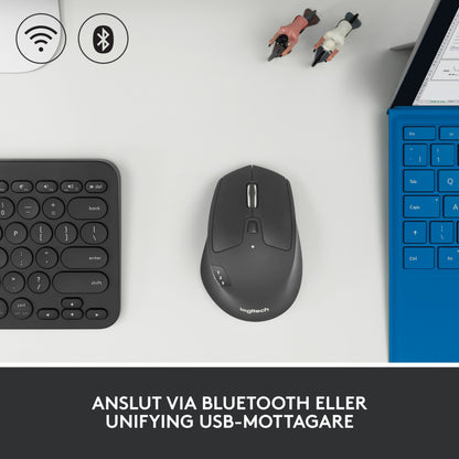 Logitech M720 trådløs mus med rullehjul og knap til skift mellem enheder på bordet ved tastaturet og den bærbare computer.