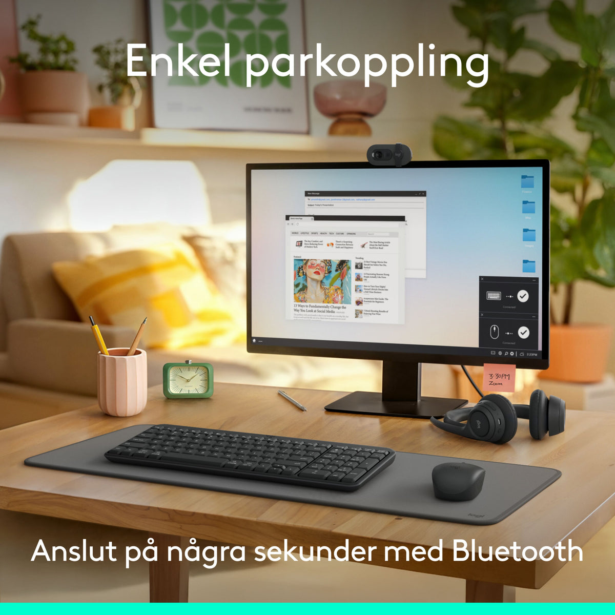 Logitech MK250 trådløst tastatur og mus på skrivebordsunderlag sammen med computerskærm, webcam og hovedtelefoner.