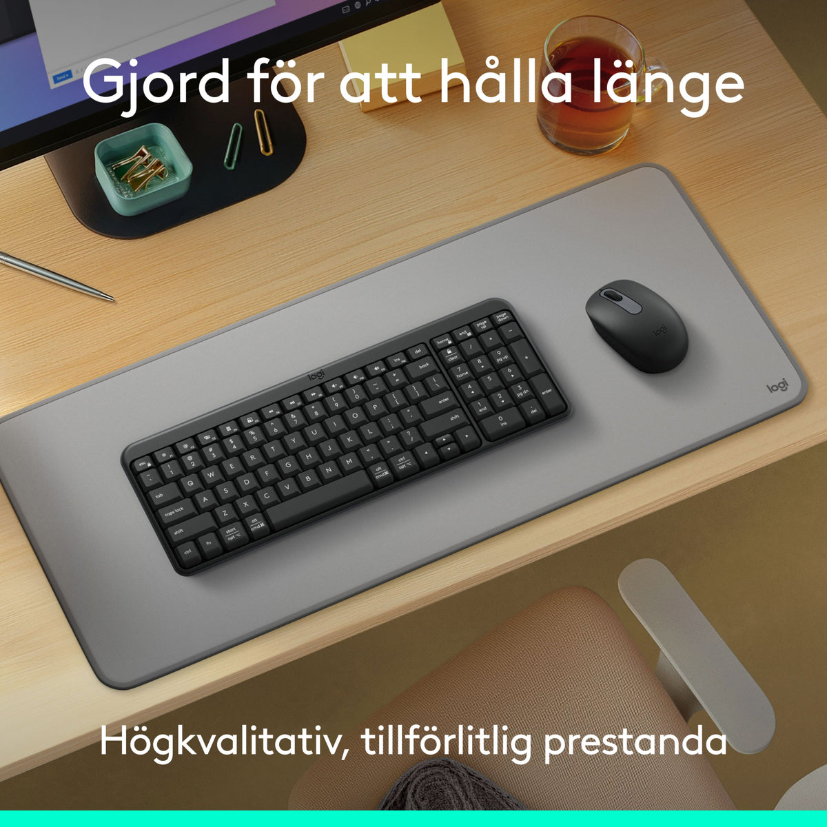 Logitech MK250 sort trådløst tastatur og mus på en grå skrivebordsunderlag på et træbord.