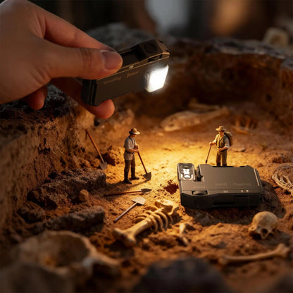 SmallRig Thumb EDC 5710 minilampe, der holdes i hånden, og som belyser miniatyrfigurer ved en udgravningsplads med knogler og værktøj.