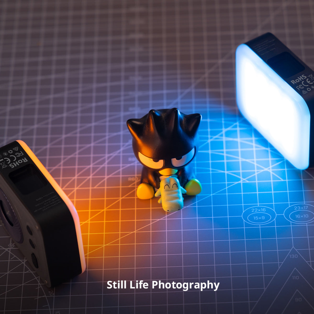 SmallRig Vibe P108 Pro mini-LED-videolampe, RGBWW, CRI 95+, 2500–6500 K, belyser en sort og grøn figur på en skæremåtte.
