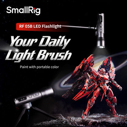 SmallRig RF 05B bærbar LED-videolampe, 1900–8000 K, IP65, med stativ og håndtag, der belyser en rød robotfigur.