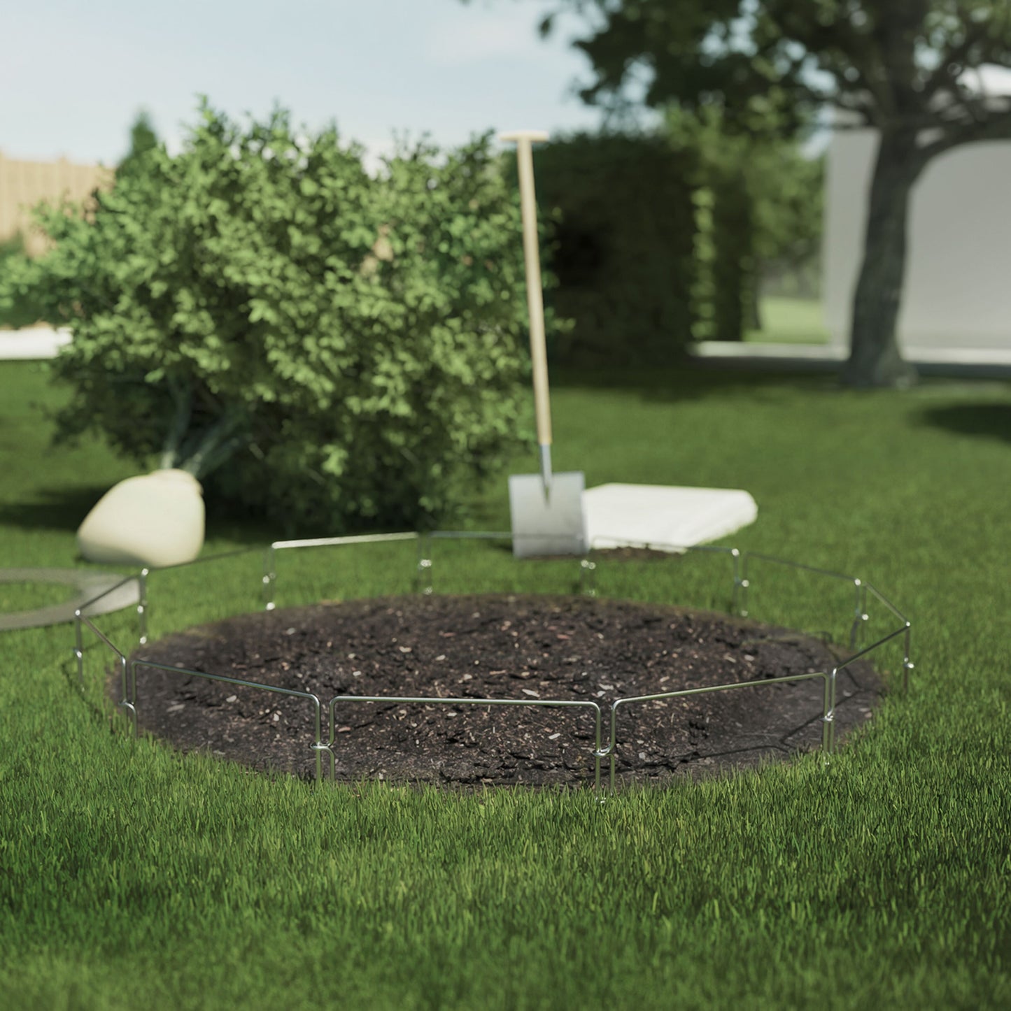 Grimsholm Hegn til robotplæneklipper 3,7 m afgrænser cirkulært bed på græsplæne med mørk jord, busk og skovl ved siden.