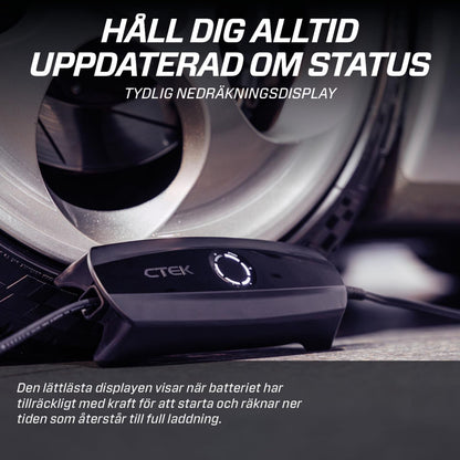 Ctek CS ONE Gen 2 smart batterioplader 12V tilsluttet bilhjul, svensk tekst viser status og nedtællingsdisplay.