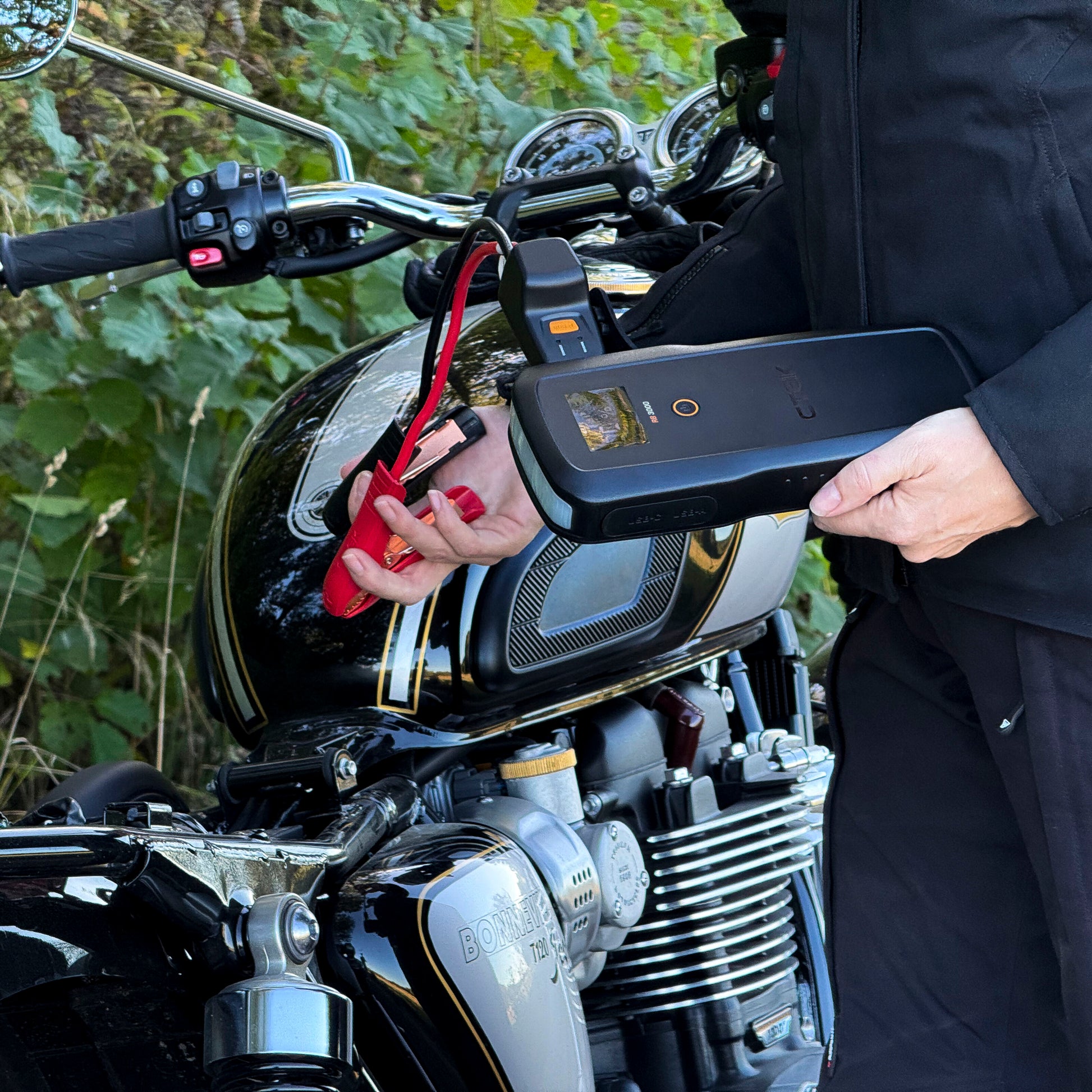 Ctek RB 3000 Startbooster 59,2 Wh med røde klemmer ved sort Triumph Bonneville T120 motorcykel, starthjælp 12V.