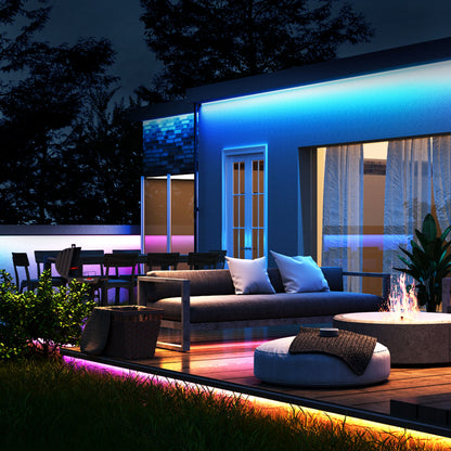 Govee Udendørs Strip Light Pro RGBICWW 10 m monteret på terrasse med ildsted, kurvestol, sofa og planter om aftenen.